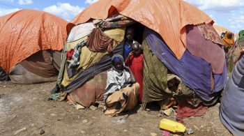 27 July 2022, Baidoa, Somalia - A mother and her children outside their makeshift shelter in Raama Cadeey IDP camp in Baidoa.